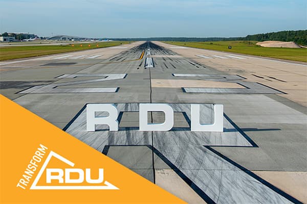 Airport runway with large RDU letters painted on pavement, green grass and trees in background, orange Transform RDU logo overlay.